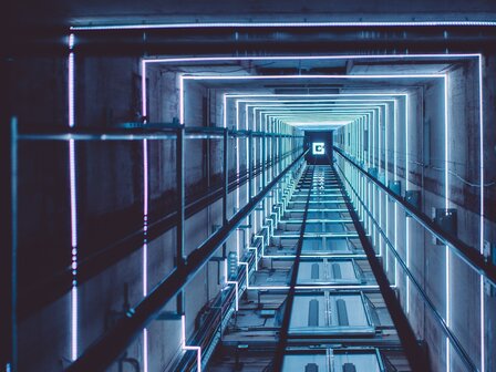 DYNLED dynamische RGB glazen schachtverlichting vanaf 5 meter, 2 vaste lichtslangen in de schacht lopen mee met de richting vd lift.