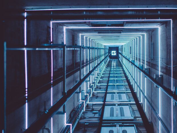 DYNLED dynamische RGB glazen schachtverlichting vanaf 5 meter, 2 vaste lichtslangen in de schacht lopen mee met de richting vd lift.